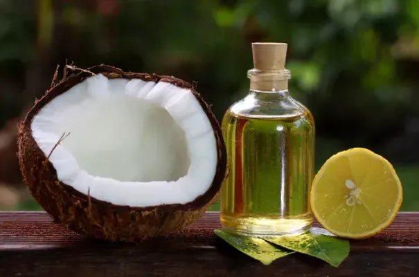 Yarım hindistan cevizi, şişede hindistan cevizi yağı ve yarım limon
